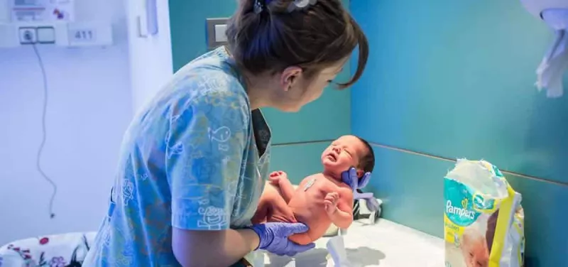 Una matrona sostiene a un recién nacido. /Archivo