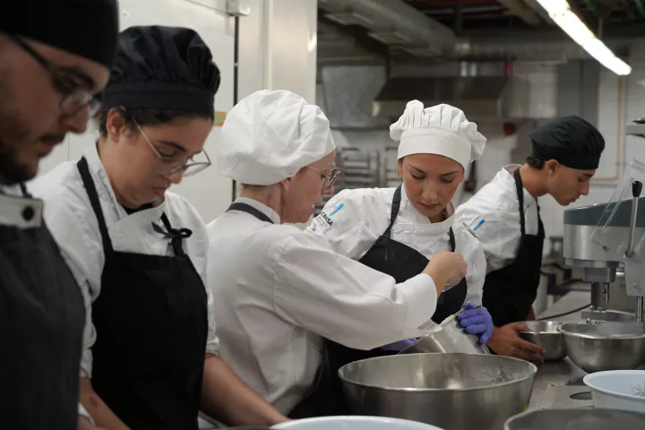 Estudiantes de Hecansa en una práctica en cocina reciben explicaciones de una docente.